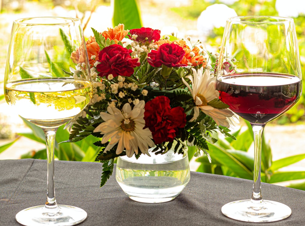 Calice vino bianco, calice di vino rosso e fiori